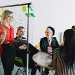 Portrait of young female team leader of talented freelances organizing work of members motivates and